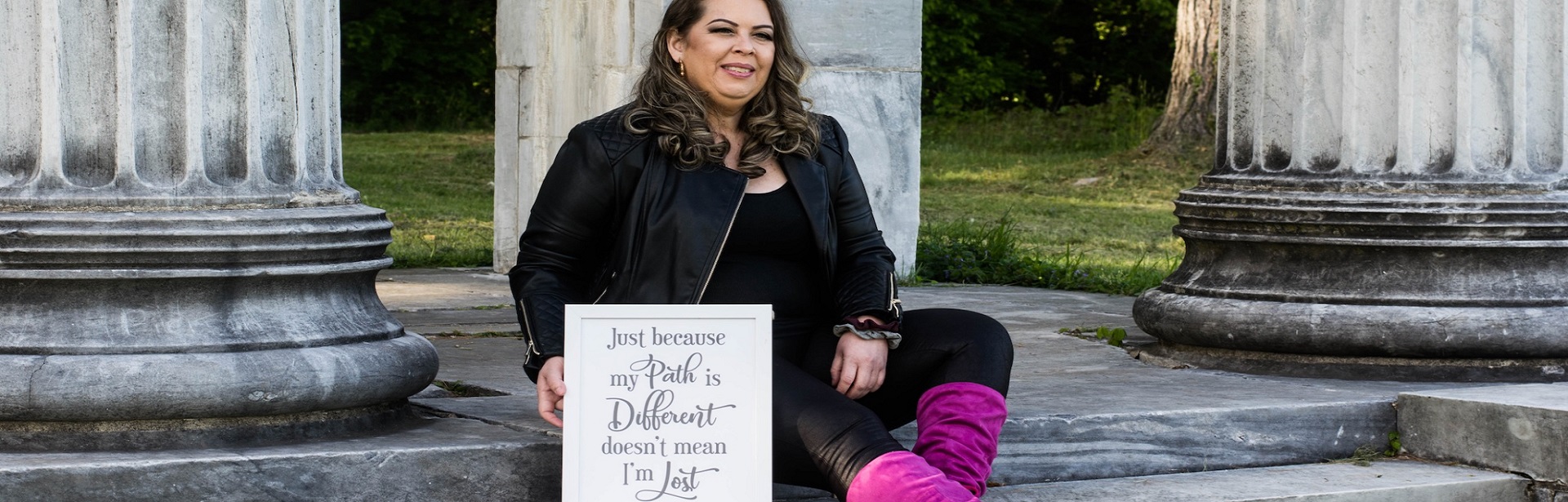 Woman Sitting with Sign on Government Building Steps